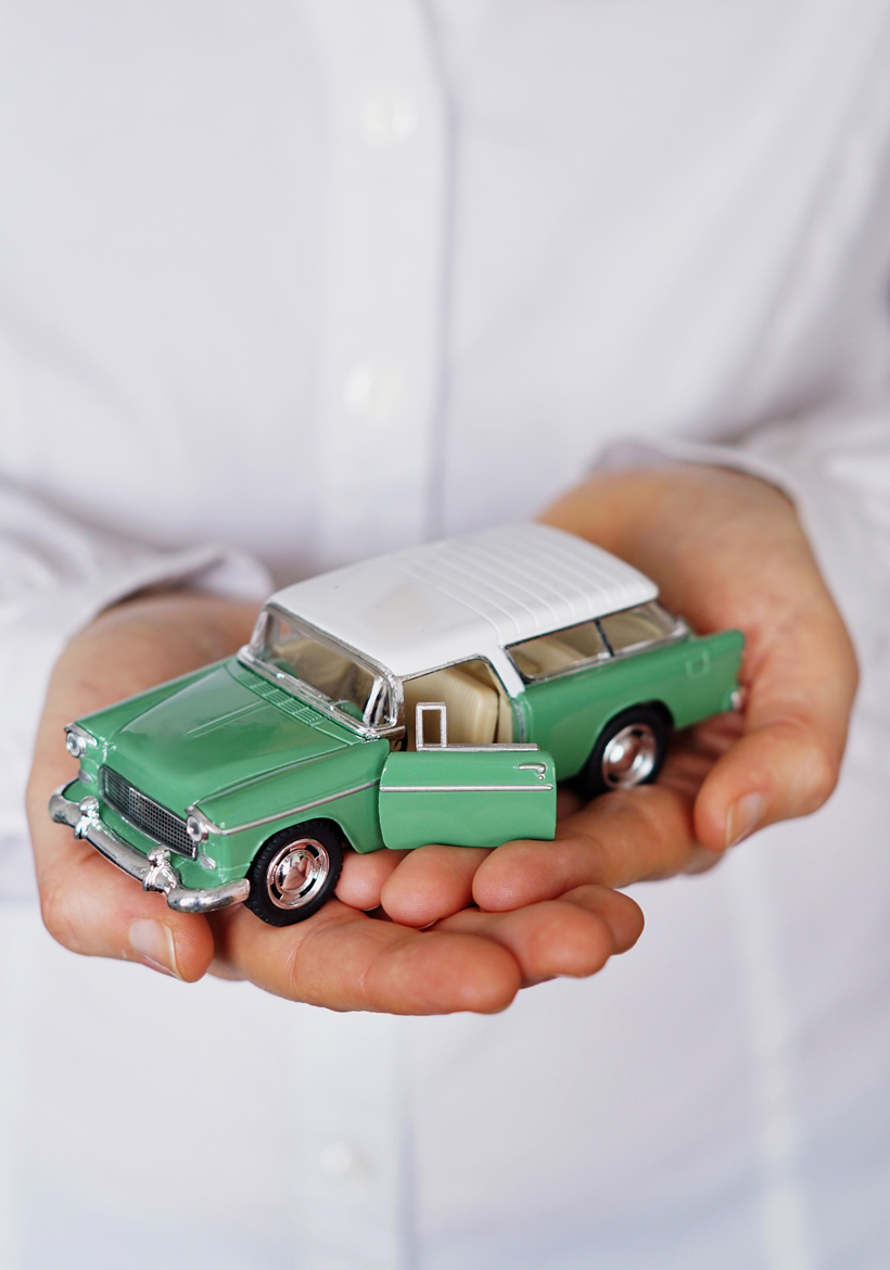 man holding a luxury mini toy car in hand
