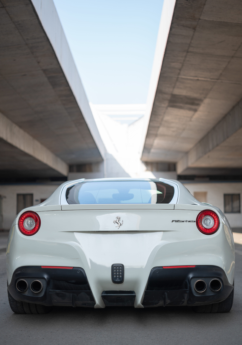 pearl white f12 ferrari parked under the bridge